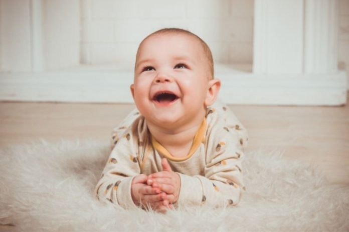 Yaz aylarında bebekler için kumaşlar - pamuklu giysiler giyen mutlu bir bebek